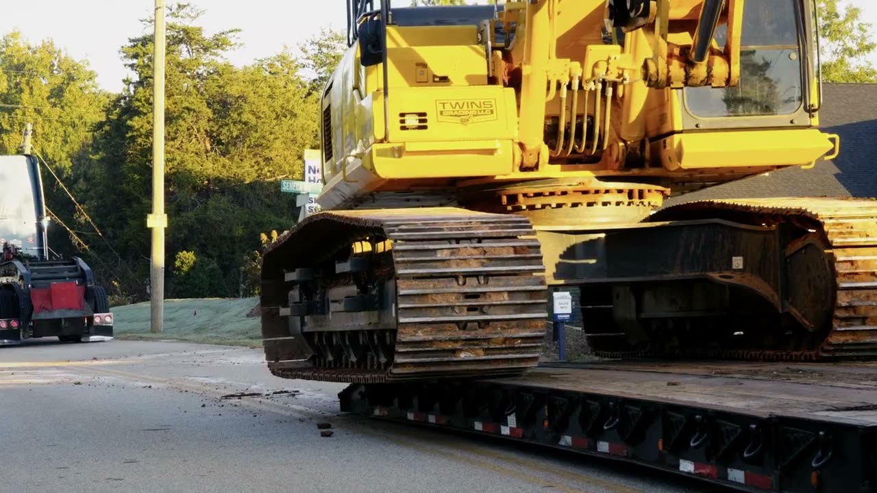 Komatsu excavator chained down on a lowboy trailer