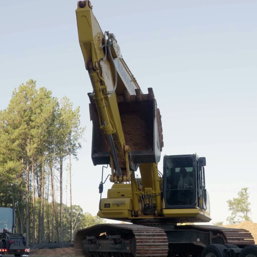 Komatsu excavator digging on a cleared job site