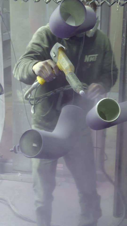 Powder coating a fabricated part inside a spray booth