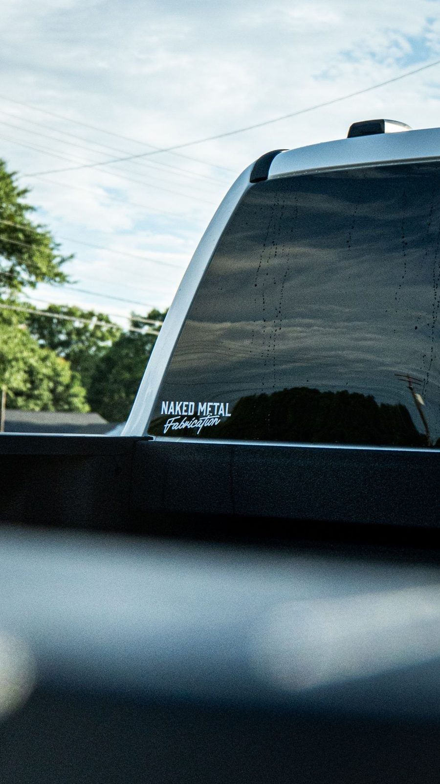 Naked Metal Fabrication decal on a truck window