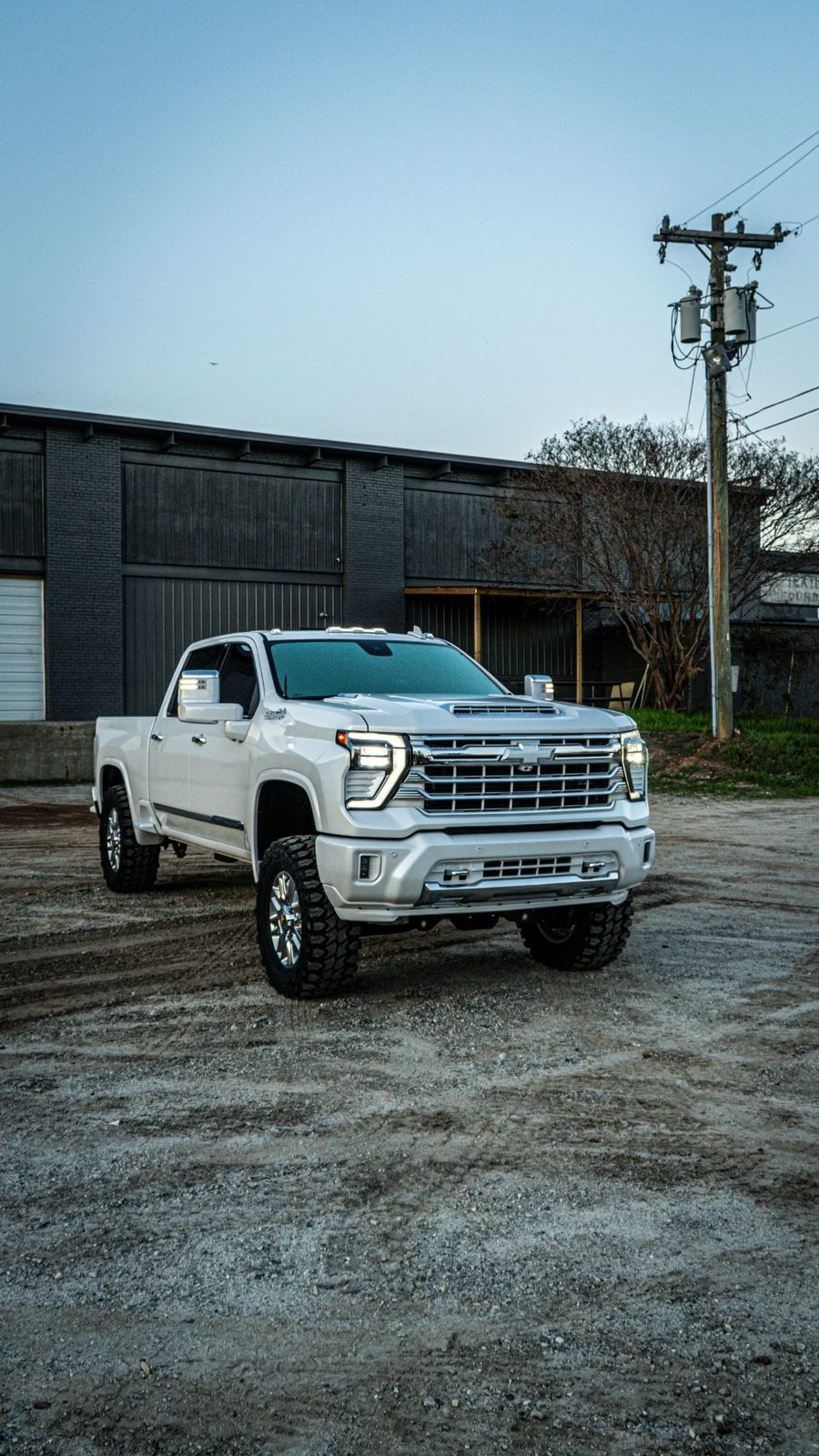 White lifted Chevy Silverado HD at dusk