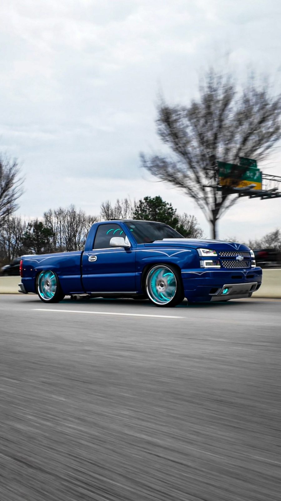 Blue custom Silverado rolling on the highway